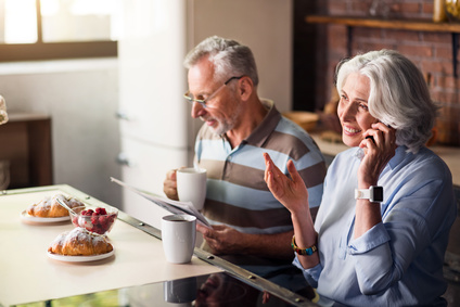 Attractive male and female pensioners having breakfast in the kitchen
